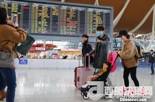 旅客帶著孩子前往辦票柜臺辦理登機(jī)手續(xù)?！∫罅⑶?攝
