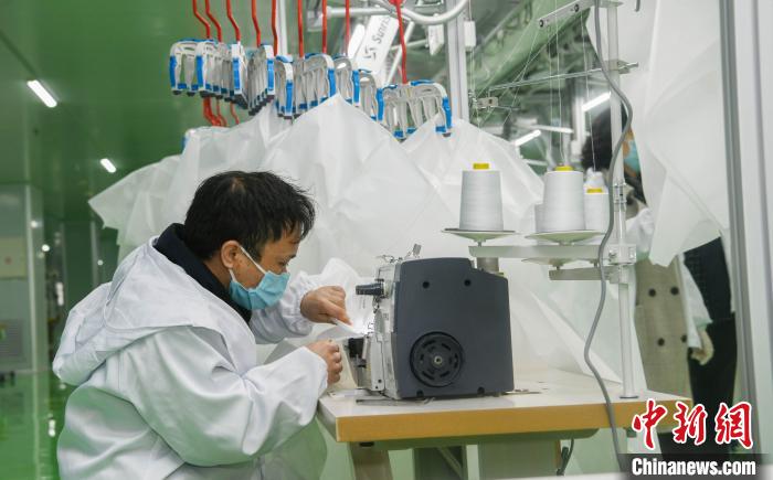 工人生產(chǎn)防護(hù)服，保障抗疫物資供應(yīng)。廣安市委宣傳部供圖