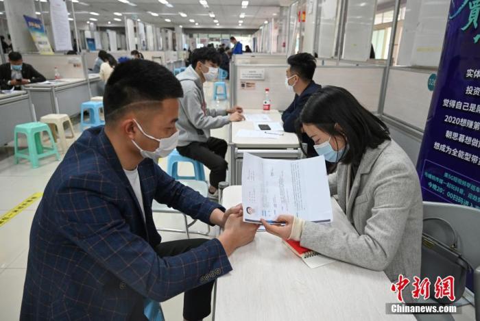 4月14日，招聘者在查看求職者簡(jiǎn)歷。<a target='_blank'  data-cke-saved- >中新社</a>記者 王剛 攝